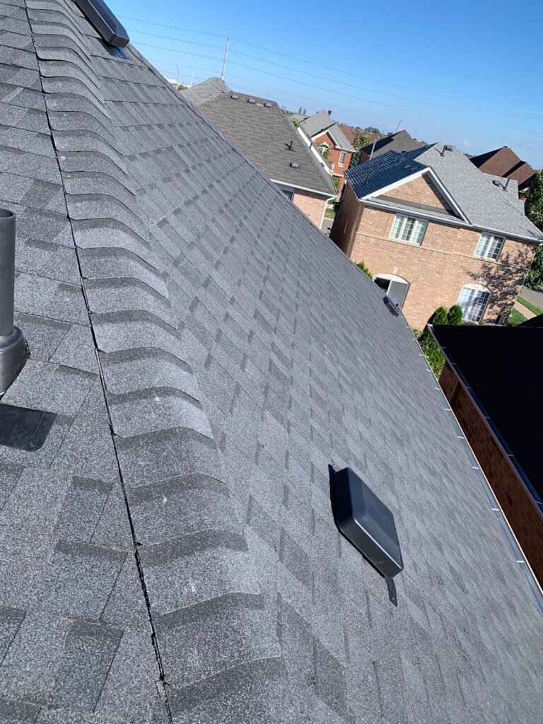 Worn asphalt shingles showing granule loss and curling edges